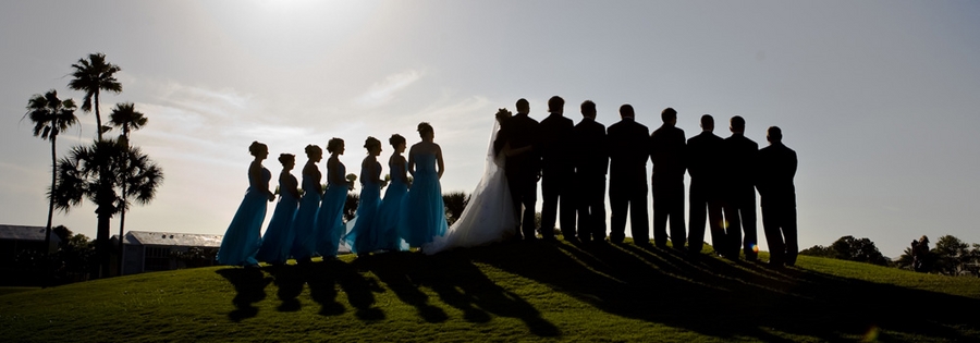 a large wedding party in silhouette with backlighting