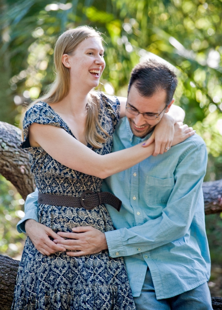 a man and woman hugging and laughing at their engagement photo session

