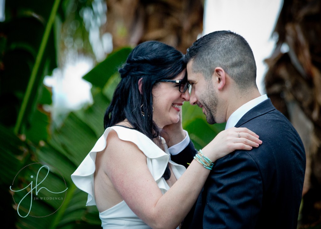 dark haired bride and groom smiling at each other in a tropical setting at their wedding in Venice Florida